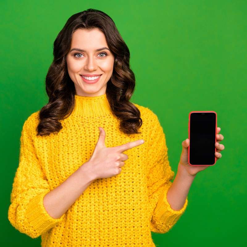 Chica sonriente mostrando su movil